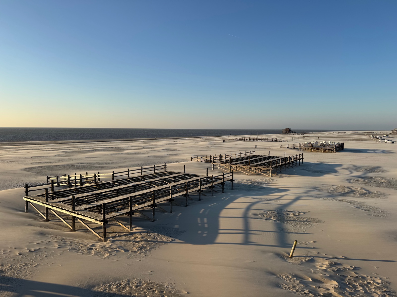 Pfahlbauten — Seebrücken und Pfahlbauten im weiten Sand mit langen Abendschatten, St. Peter-Ording