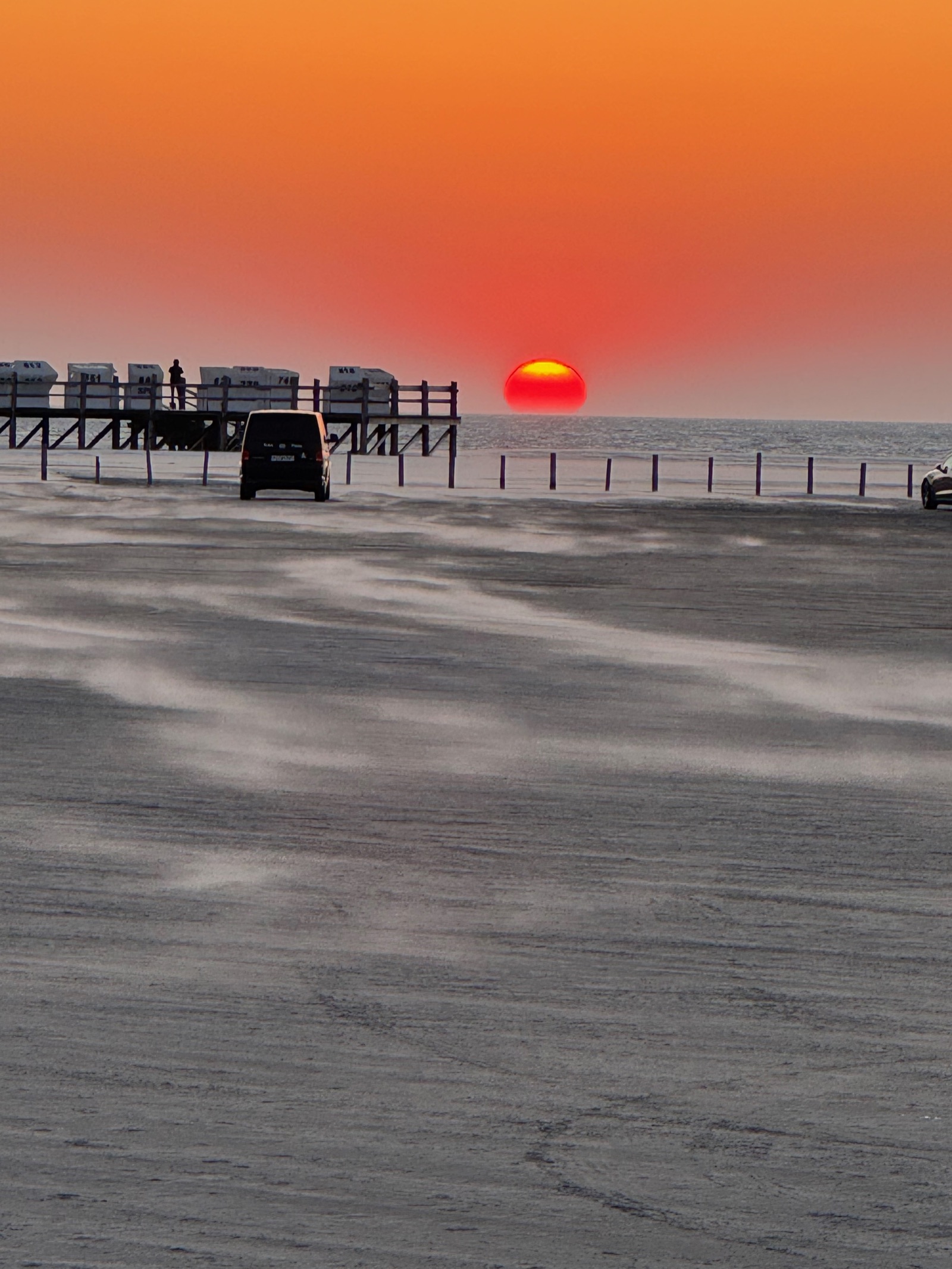 Strandkörbe — Reihen von Strandkörben auf Stelzen vor tiefroter untergehender Sonne, St. Peter-Ording