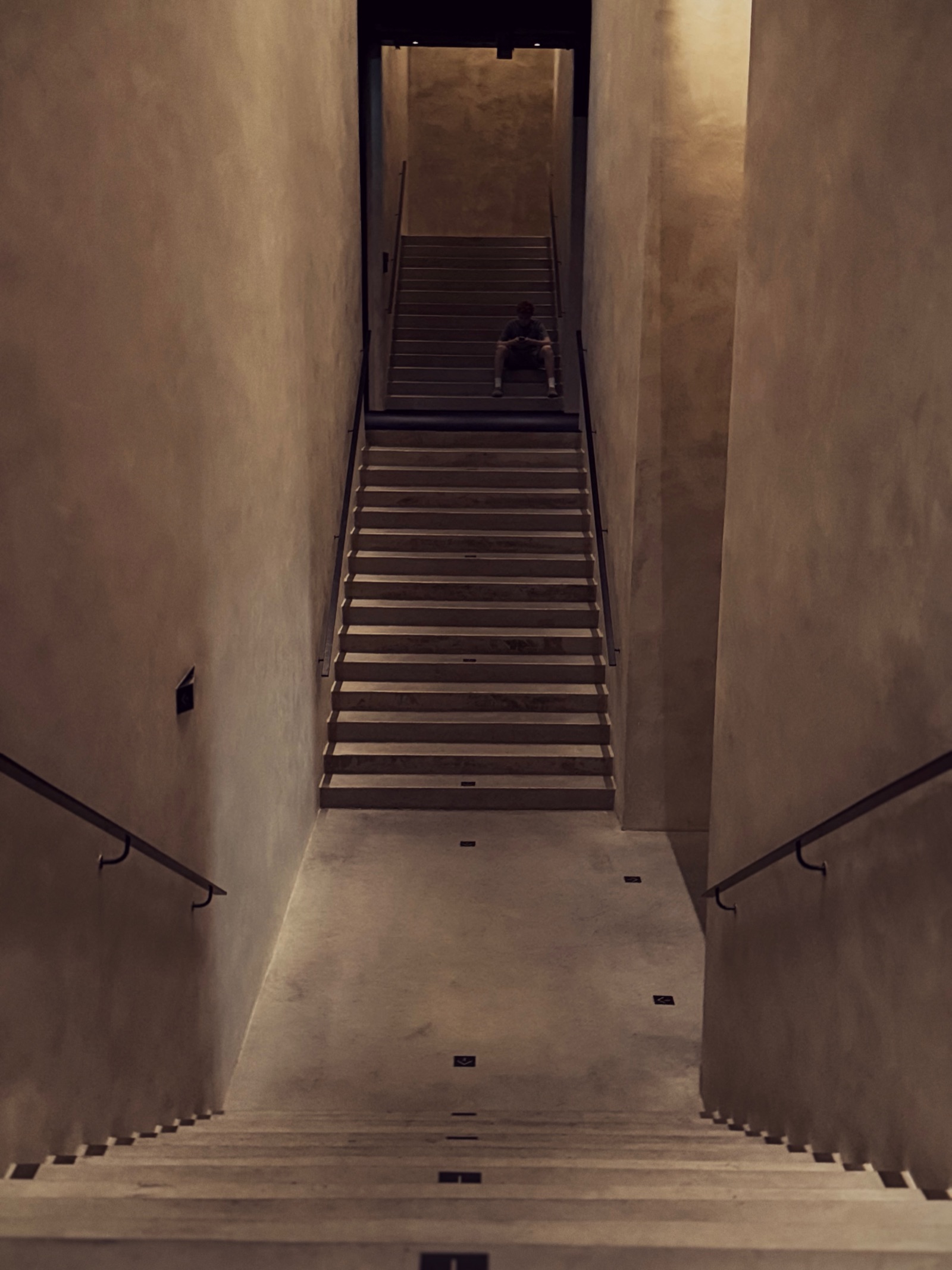 Aufgang — strenge Betontreppe in warmem Licht, minimalistische Architektur, Mailand