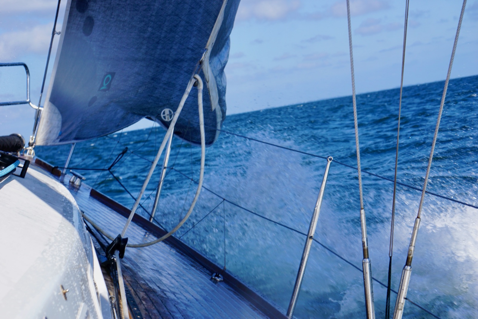 An Deck — Segelyacht krängt, Gischt über dem Teakdeck, Ostsee · Randlicht Fotografie